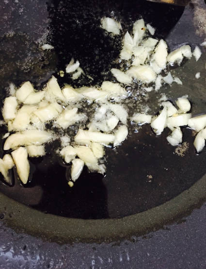 Stir fry garlic in a wok.