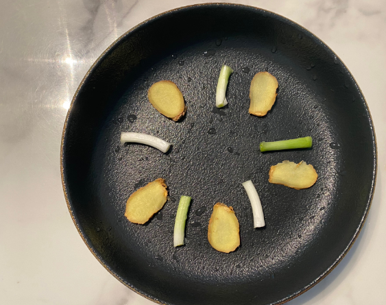 Place ginger slices and scallions on the bottom of the steaming plate.