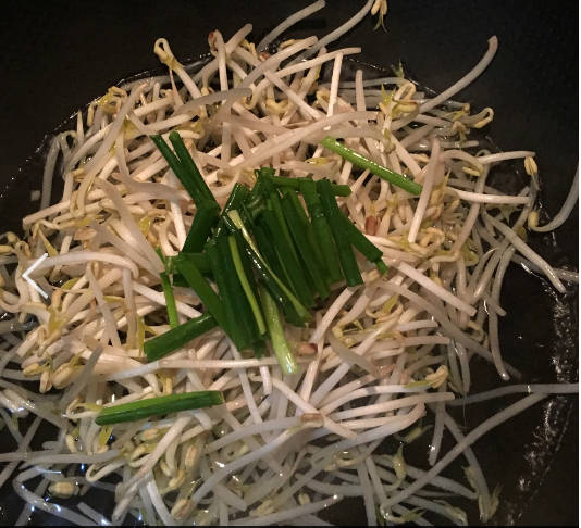 Add water into the pot, bring to a boil over high heat, add bean sprouts and scallions, and cook them.