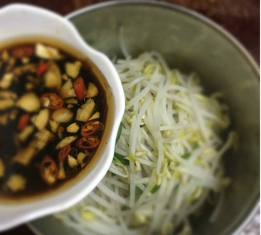 Take out the bean sprouts and drain them, put them into a bowl, pour in the sauce that has just been mixed, and stir it evenly before eating.