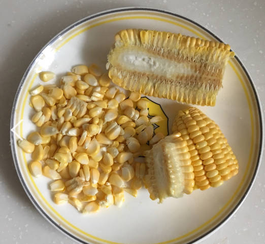 Then cut it in the middle with a knife, and peel the corn grain along the vertical line to the side. The tender corn is easier to cut. Be careful not to cut your hand.