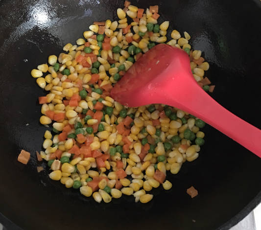 Pour in corn, carrot, and peas and stir for two minutes.