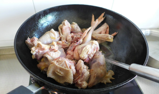 Pour the soaked chicken pieces into the pot and stir them until they change color;