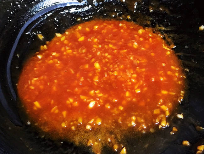 Add 4 tablespoons of water, 2 tablespoons of sugar, 4 tablespoons of tomato paste, and some salt and stir well until slightly bubbling.
